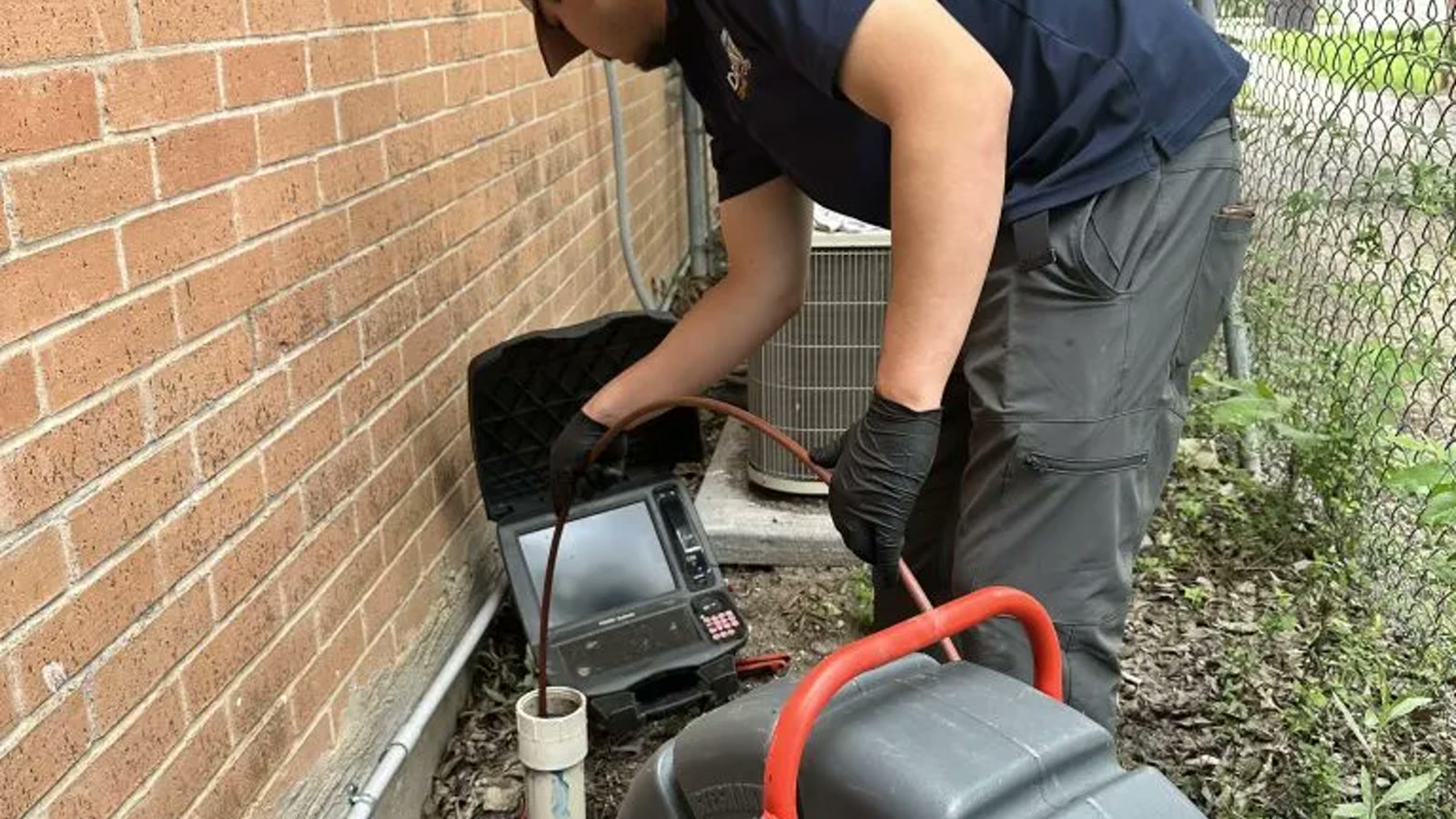 Drain technician performing a residential camera inspection